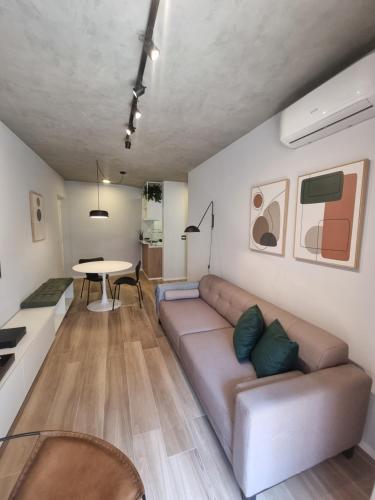 uma sala de estar com um sofá e uma mesa em 1031 - London Class Suítes em São Paulo