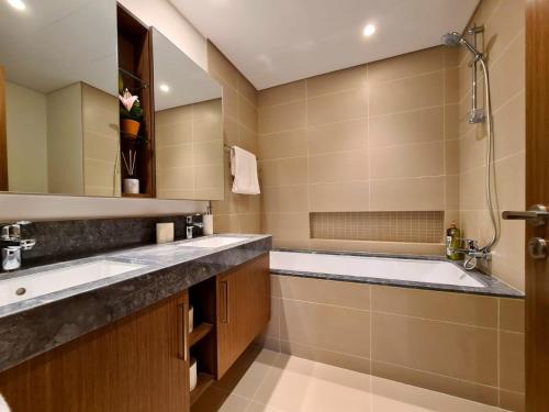 杜拜的住宿－Luxury Marina Apartment 1，浴室配有两个盥洗盆和浴缸。