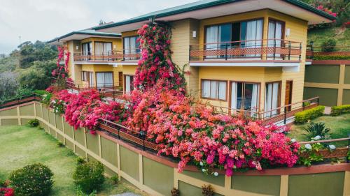 un bâtiment avec des fleurs sur son côté dans l'établissement Hotel Ficus - Monteverde, à Monteverde Costa Rica