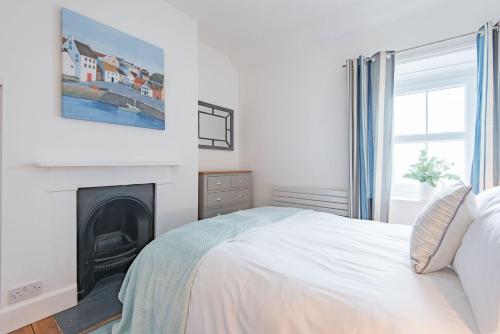 Dormitorio blanco con cama y chimenea en Wave Cottage by Bloom Stays en Sandgate