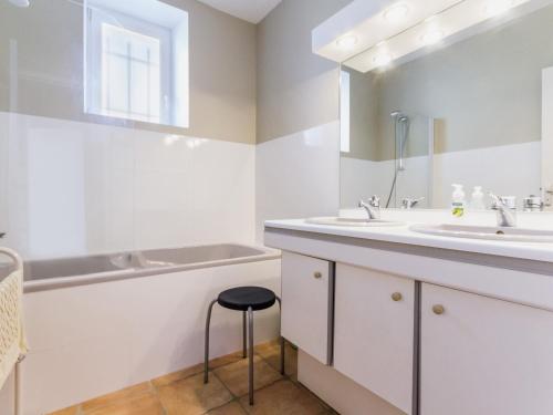 ein weißes Badezimmer mit einem Waschbecken und einem Stuhl in der Unterkunft Gîte Saint-André-des-Eaux, 4 pièces, 8 personnes - FR-1-306-1125 in Saint-André-des-Eaux