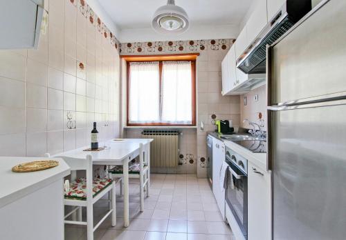 a white kitchen with a table and a refrigerator at Villa Marchionni in Cese