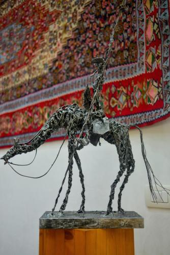 a metal statue on a table with a rug at Hotel Malpensafiera in Bernate Ticino