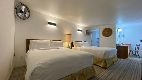 a hotel room with two beds and a table at The Aztec Motel & Creative Space in Seligman