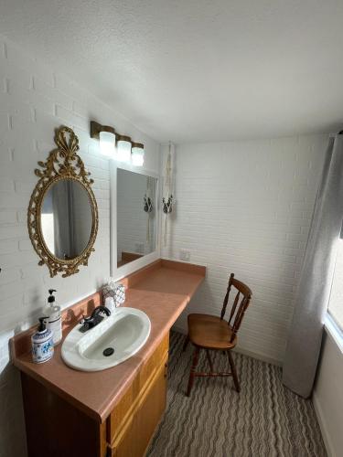 a bathroom with a sink and a mirror and a chair at The Aztec Motel & Creative Space in Seligman
