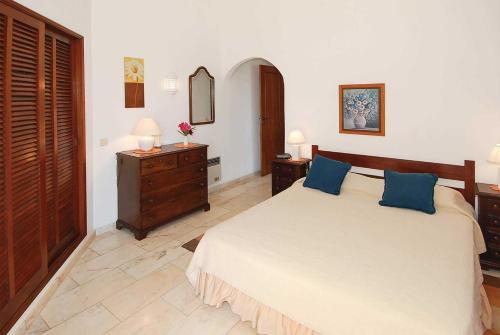 a bedroom with a large bed with blue pillows at Casa Monte Mimosa in Carvoeiro