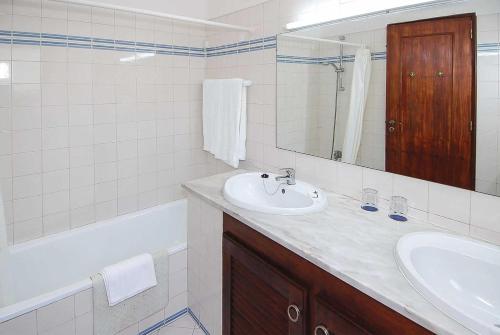 a bathroom with a sink and a mirror and a tub at Casa Monte Mimosa in Carvoeiro