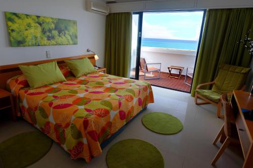 a bedroom with a bed and a view of the ocean at Rocamar Exclusive Hotel & Spa - Adults Only in Albufeira