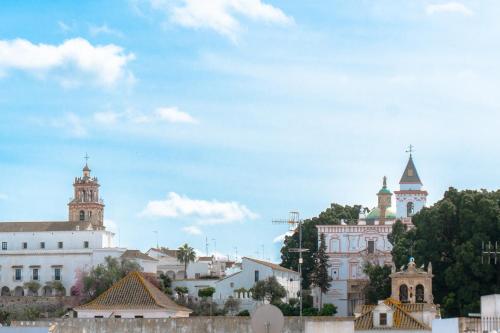 a group of buildings with a blue sky in the background at Ático Imperial GARAJE GRATIS Céntrico Terraza Aire Acond Solarium 2 baños wifi a 1minuto de la Plaza Cabildo in Sanlúcar de Barrameda