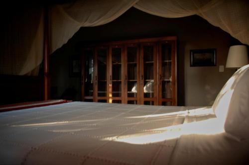 a bedroom with a white bed and a wooden cabinet at Terra Dos Goitis - Chalés - Pipa in Pipa