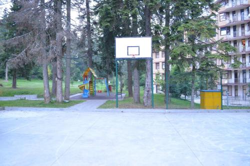 a basketball hoop in a park with a playground at Persey Flora Apartments in Borovets