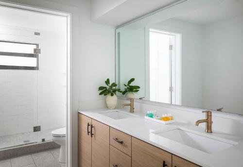 a white bathroom with a sink and a mirror at La Siesta Resort & Villas in Islamorada