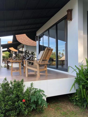 a patio with a chair and a table at Little Moon Villa in Ko Mak