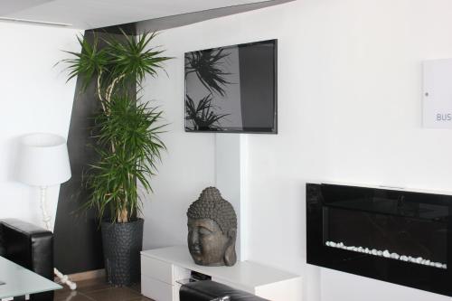 a living room with potted plants and a television at Rocamar Exclusive Hotel & Spa - Adults Only in Albufeira