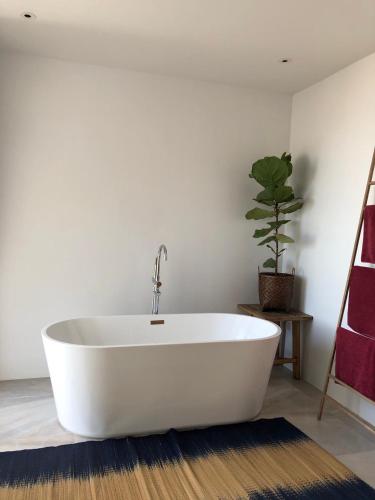 a white bath tub in a bathroom with a potted plant at Little Moon Villa in Ko Mak