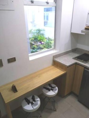 a kitchen with two chairs and a counter with a window at Zenia 70 Living & Suites in Medellín