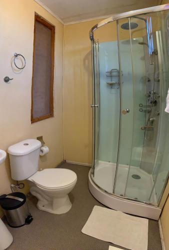 a bathroom with a toilet and a glass shower at Sami Atacama in San Pedro de Atacama