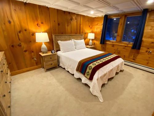 Una cama o camas en una habitación de Amazing lakefront home in the White Mountains with game room theater