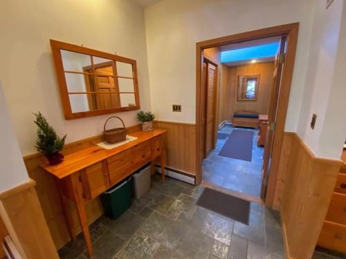 een badkamer met een houten wastafel en een spiegel bij O4 - NEW 1 minute walk from beginner ski trail in the heart of Bretton Woods in Carroll