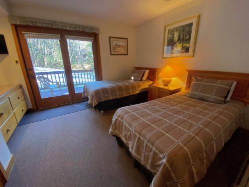 een hotelkamer met 2 bedden en een balkon bij O4 - NEW 1 minute walk from beginner ski trail in the heart of Bretton Woods in Carroll