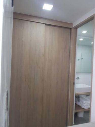 a bathroom with a wooden closet with a mirror at Zenia 70 Living & Suites in Medellín