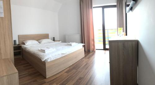 um quarto com uma cama e uma grande janela em Plai Dobrogean em Greci