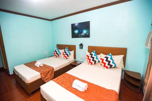 2 camas en una habitación con paredes azules en Isla Vista Beach Resort, en Candelaria