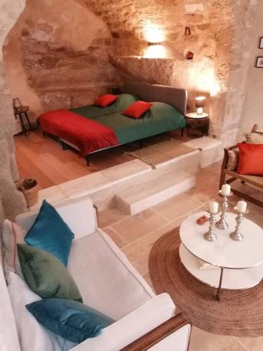 une chambre avec un lit, un canapé et une table dans l'établissement La Maison d’Helene & Antoine à Bonnieux XII siècle, à Bonnieux