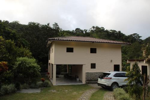 a white car parked in front of a house at Cabaña Kundalini in Antón