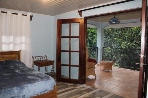 Schlafzimmer mit einem Bett und einer Glasschiebetür in der Unterkunft Cabaña Kundalini in Antón
