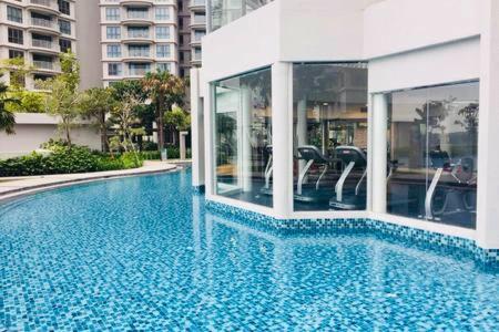 a swimming pool with blue water in a building at Johor Malaysia Teega Suites@ Puteri Harbour Condo 4607 Persiaran Lasamana , Teega Suites in Nusajaya