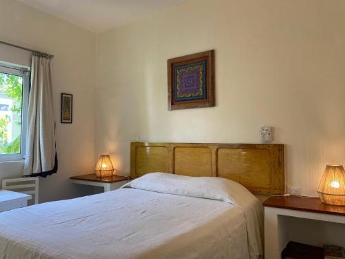 a bedroom with a bed and two lamps on two tables at Hotel La Piazzetta in Mérida