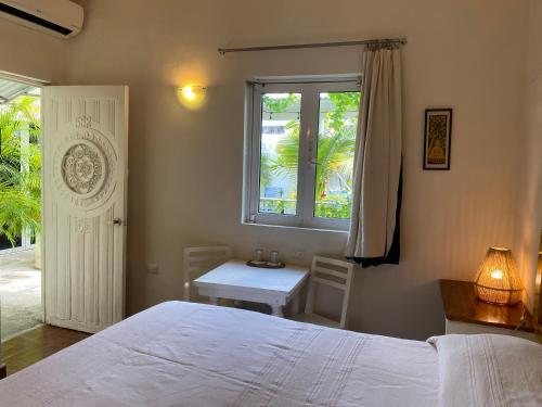 a bedroom with a bed and a window and a table at Hotel La Piazzetta in Mérida
