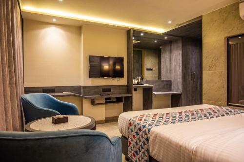 a hotel room with two beds and a tv at Suvidha Suites in Vasai