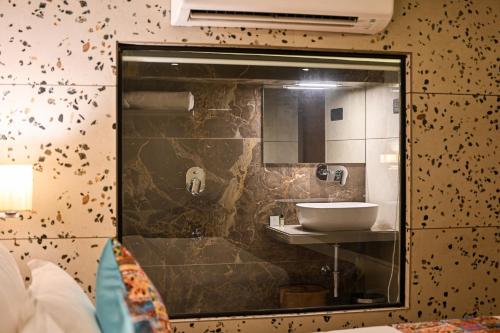 a bathroom with a sink and a mirror at Suvidha Suites in Vasai