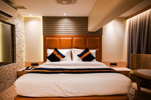 a bedroom with a large bed with a wooden headboard at Suvidha Suites in Vasai