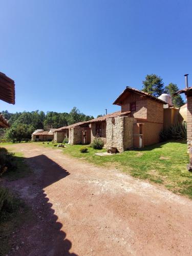 un chemin de terre devant un groupe de bâtiments dans l'établissement Luchita Mia Eco Cabañas Boutique, à Zacatlán