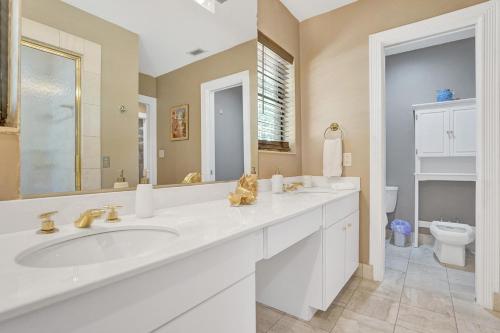 a bathroom with two sinks and a toilet at Modern 6br Villa Resort Style Pool On Golf Course in Pompano Beach