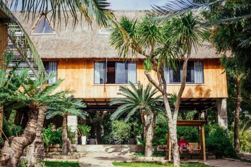 a person sitting on a bench in front of a house at Villa Đảo Hoa Vàng Cam Ranh - Venuestay in Cam Ranh