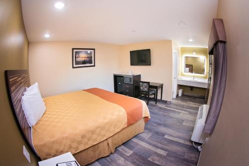 a hotel room with a bed and a desk at GAREY MOTEL in Pomona