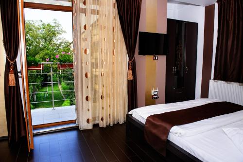 1 dormitorio con cama y ventana grande en Vila HD, en Hunedoara