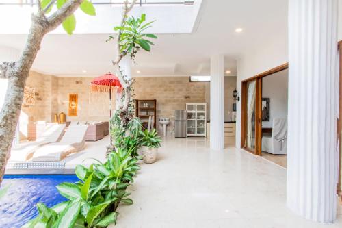 an open living room with a pool in the middle of a house at Villa Aviya in Jimbaran