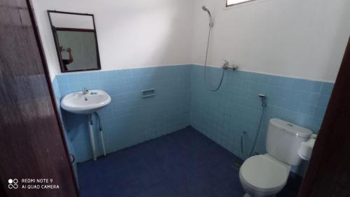 ein Bad mit einem WC und einem Waschbecken in der Unterkunft Leokap Homestay in Tuk Tuk