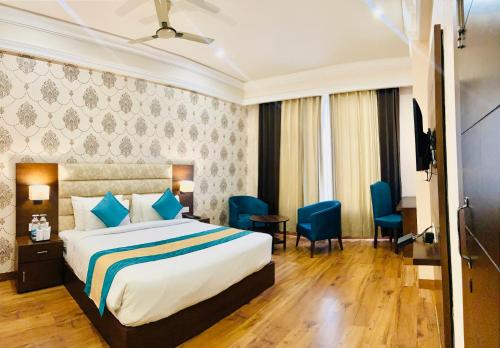 a hotel room with a bed and a television at Sterling Mantra Haridwar in Haridwār