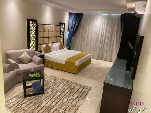 een hotelkamer met een bed en een bank bij Al Lord Hotel in Abū Qa‘ar