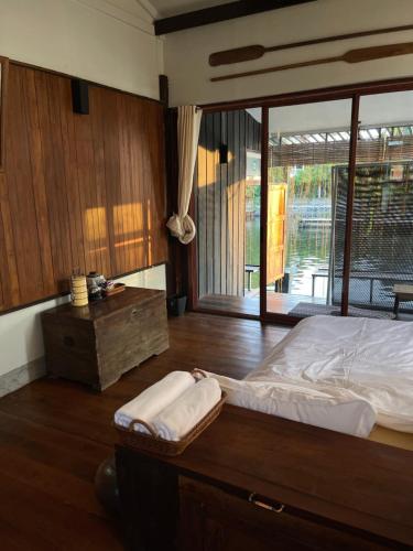 a bedroom with a bed and a wooden floor at Humz Canal Stay in Nonthaburi