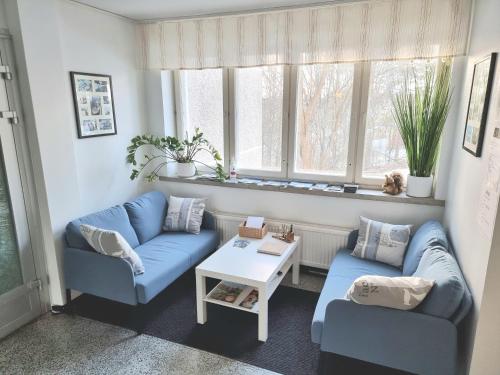 a living room with two blue couches and a table at Vanha-Merivartioasema in Kotka
