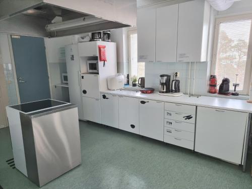 a kitchen with white cabinets and a refrigerator at Vanha-Merivartioasema in Kotka