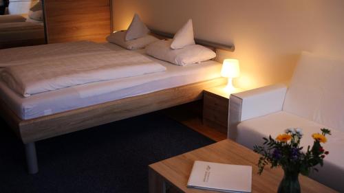 a bedroom with a bed and a table with a lamp at Sonnleiten-Rupert in Bad Griesbach