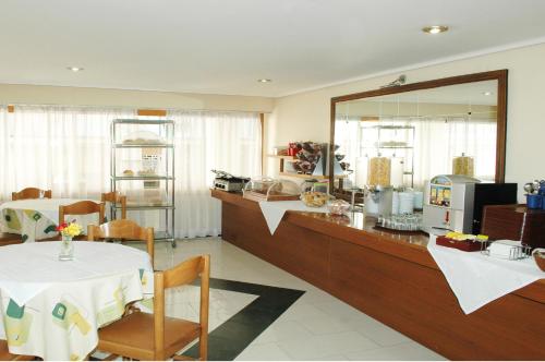a kitchen with a table, chairs and a refrigerator at Omiros Hotel in Athens
